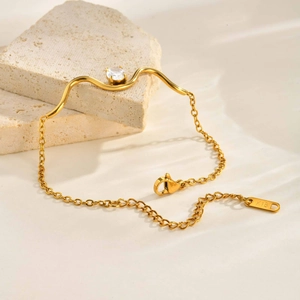 Detail eines 18K vergoldeten Wellenarmbands mit ovalem Zirkon und K18-Stempelung