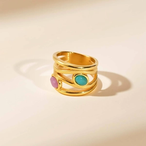 Detail showing gold wide multilayer band ring with oval light purple and teal stones