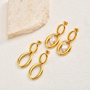Detail view of gold oval geometric earrings with minimalist metal and zircon inlay