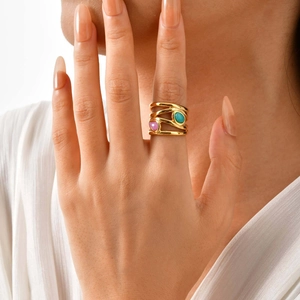 Multi-layer gold-plated ring with pink and turquoise stones shown on model hand