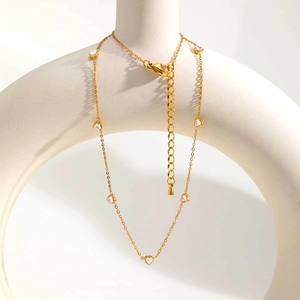 Collier en acier inoxydable doré avec pendentifs cœurs en zircon sur support minimaliste