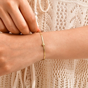 Détail du bracelet chaîne serpent en or 18 carats avec breloques fleurs sur le poignet