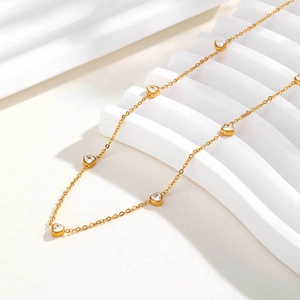 Détail du collier pendentif cœur doré avec zircon blanc sur marches blanches
