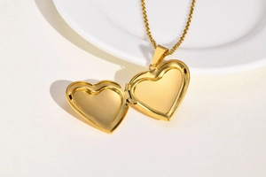 Macro shot of an open gold heart locket pendant showing the interior photo space