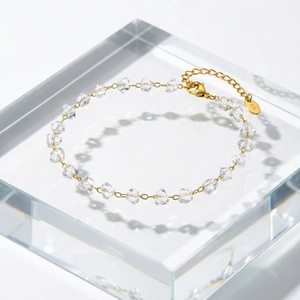Macro detail of 14K gold-plated irregular clear crystal beads on a chain bracelet