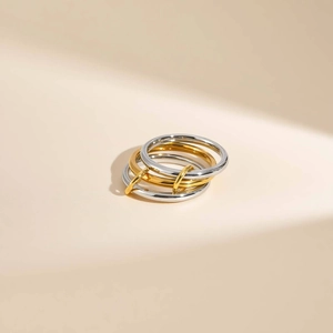 Macro detail of linked two-tone stainless steel rings with polished metal finish