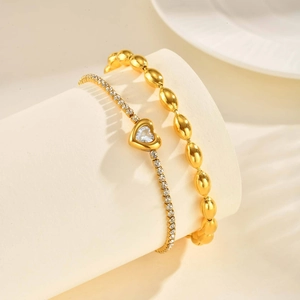 Detail of gold-plated bracelet set with heart-shaped zircon and polished beads