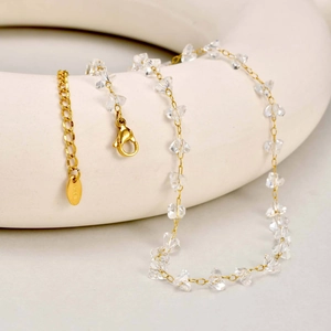 Macro detail of the K18 gold-plated chain featuring clear irregular quartz beads and clasp