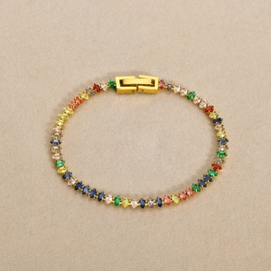 Dettaglio macro del bracciale in acciaio dorato con zirconi marquise arcobaleno