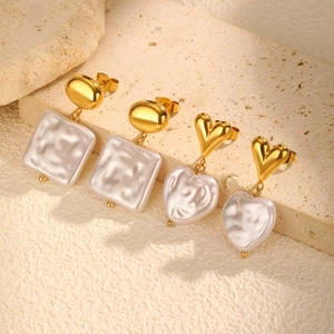 French style 18k gold plated pearl drop earrings set on a travertine stone base