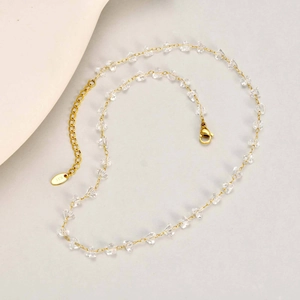 Elegant gold necklace featuring transparent heart crystals and a K10 metal brand tag