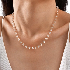 Detail of gold chain necklace with raw transparent quartz stones on a model