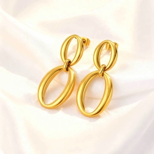 Polished gold stainless steel double oval hoop earrings on white silk background