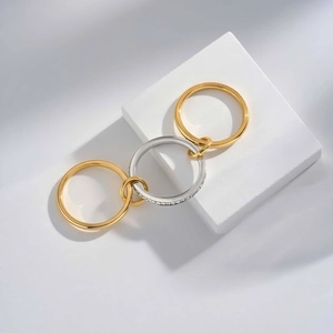 Close-up of interlocking gold and silver rings with cubic zirconia pave on stone base