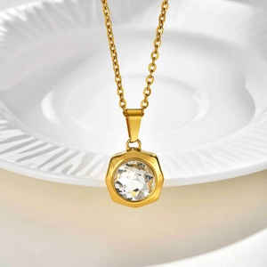 Vue macro d'un collier en acier doré avec pendentif hexagonal en zircone blanc