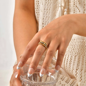 Close-up of double-layer gold stainless steel ring with pavé zircons worn on model's finger