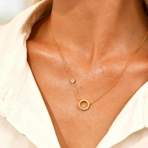 Collier anneau ovale en acier inoxydable doré avec zircons sur un mannequin