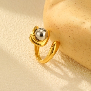 Detailed view of an irregular gold open ring featuring a contrasting silver metal bead accent