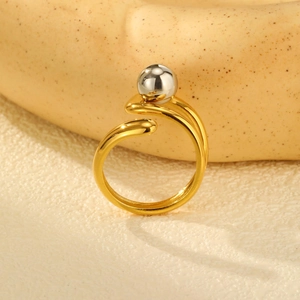 Detail of minimalist open ring with gold band and a polished silver bead accent