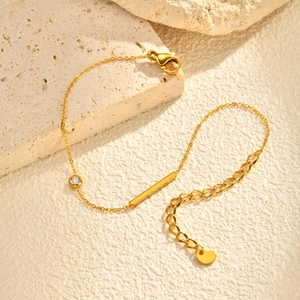 Détail d'un bracelet doré en acier inoxydable avec barre rectangulaire et zircon sur pierre