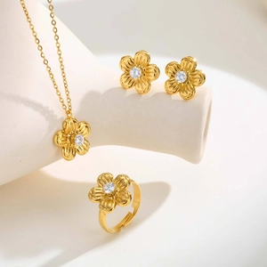 Detalle de conjunto de joyas florales doradas con circones y textura de pétalos