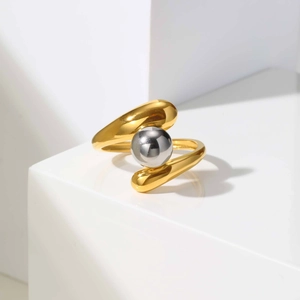 Detail of two-tone open ring featuring a gold irregular band and a silver spherical bead