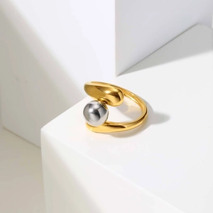 Detailed view of bicolor irregular ring with gold band and a large silver metal bead