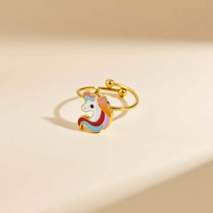 Detalle de una cabeza de unicornio en esmalte colorido y esferas doradas en un anillo