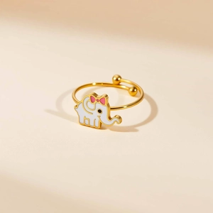 Detalle de anillo dorado ajustable con un tierno elefante blanco de esmalte y lazo