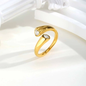 Detail of gold open ring with dual zircon stones on a minimalist white architectural background