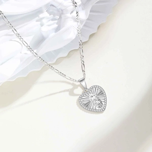 Détail chaîne Figaro et pendentif cœur avec relief Vierge Marie et oxydes de zirconium