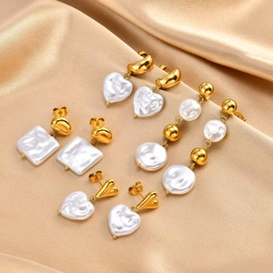 Detailed view of four pairs of 18k gold-plated earrings with baroque pearls on silk fabric