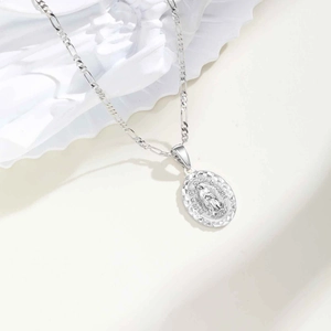 Vue macro du pendentif ovale Notre-Dame de Guadalupe en argent sur chaîne Figaro