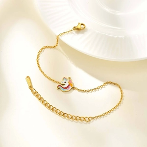 Detalle de una pulsera de acero dorado con un dije de unicornio esmaltado de colores