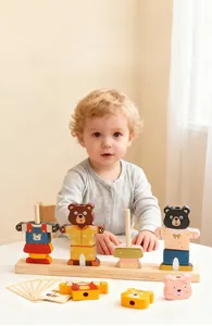Detail of toddler playing with wooden bear dress-up puzzle and color matching sorting blocks