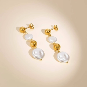 Detail of elegant gold beaded drop earrings featuring tiered baroque pearl elements