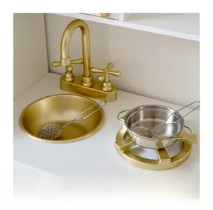 Detailed view of luxury gold faucet and stainless steel cookware for kids wooden kitchen