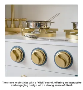 Detail of wooden play kitchen with golden knobs and stainless steel cookware set