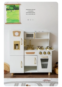Detailed view of a white and gold wooden play kitchen with stove, oven, and sink for kids