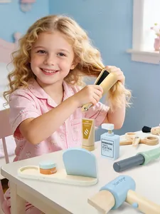 Dettaglio di un bambino che gioca con kit parrucchiere in legno dai colori pastello