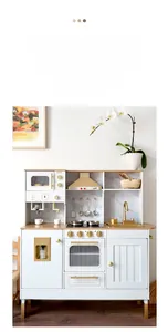 Detail view of wooden play kitchen with white panels and elegant golden faucet hardware