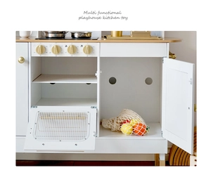 Close-up of wooden toy kitchen knobs and storage cabinet with gold accents