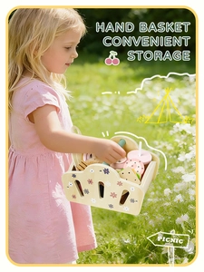 Fillette tenant un panier de pique-nique en bois fleuri avec des jouets sur l'herbe