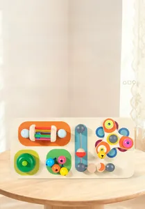 Dettaglio della busy board in legno con ingranaggi colorati e sonaglino per bambini