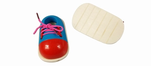 Macro view of wooden shoe toy for lacing practice with pink laces and non-slip wood base