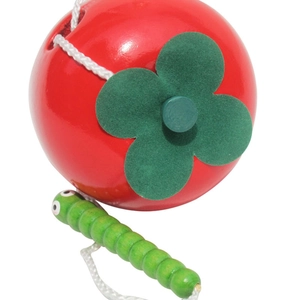 Close-up of wooden apple threading toy with green caterpillar bead and white string