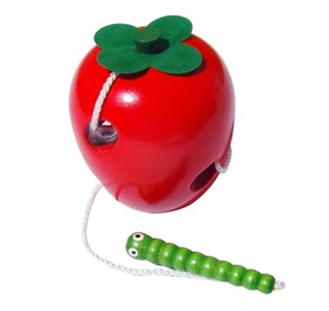 Detail of wooden apple threading toy with a white string and caterpillar needle for toddlers
