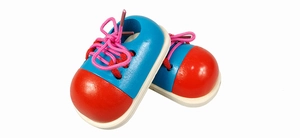Macro detail of wooden educational toy shoes with red toes and pink woven laces