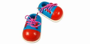 Close-up of wooden lacing shoe toy with colorful red and blue panels for skill learning