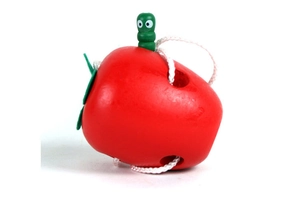 Macro detail of wooden apple threading toy with green caterpillar and white string